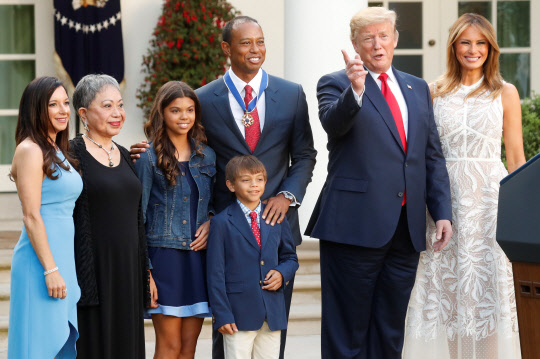 '골프황제'타이거 우즈가 6일(현지시간) 트럼프 대통령이 수여하는 자유메달을 목에 걸고 가족과 함께 기념촬영을 하고 있다.   로이터연합뉴스